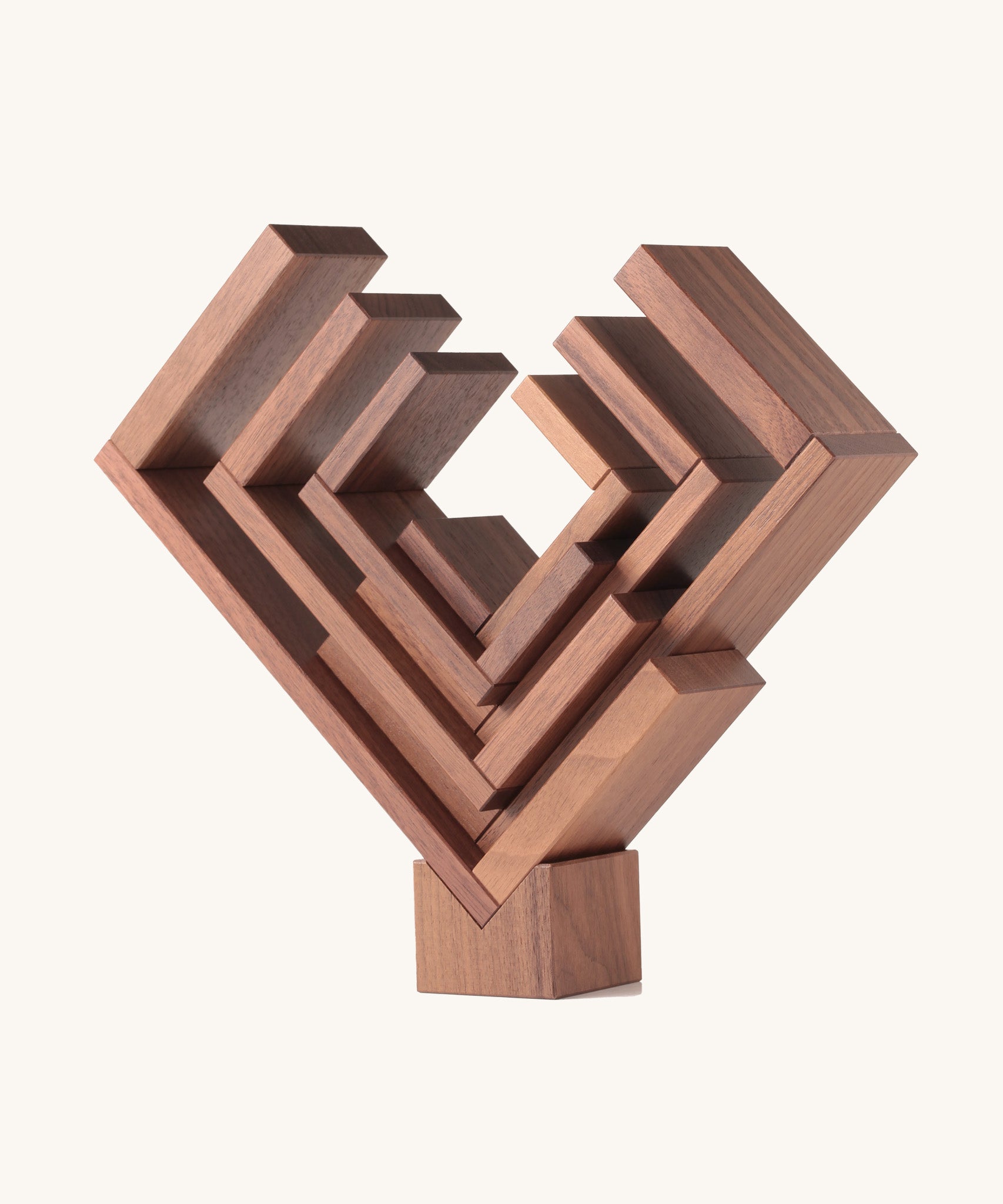 The Naef Corus walnut wood stacking toy, stacked on top of the cubic keystone to create a mesmerising geometric sculpture.