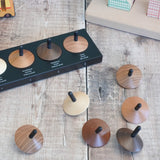 Naef loose wooden spinning tops with a black stem on a wooden surface 