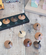 Naef loose wooden spinning tops with a black stem on a wooden surface 