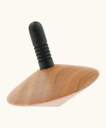 Naef handcrafted wooden spinning top showing a black stem with grooves for grip 