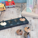 Naef wooden spinning tops loose on a wooden surface with vehicles and building blocks in the background