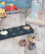 Naef wooden spinning tops loose on a wooden surface with vehicles and building blocks in the background