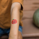 Pumpkin tattoo from the Namaki Halloween face painting kit applied to a child's arm.