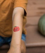 Pumpkin tattoo from the Namaki Halloween face painting kit applied to a child's arm.