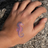 Seahorse tattoo from the Namaki mermaid face painting kit applied to a child's hand.