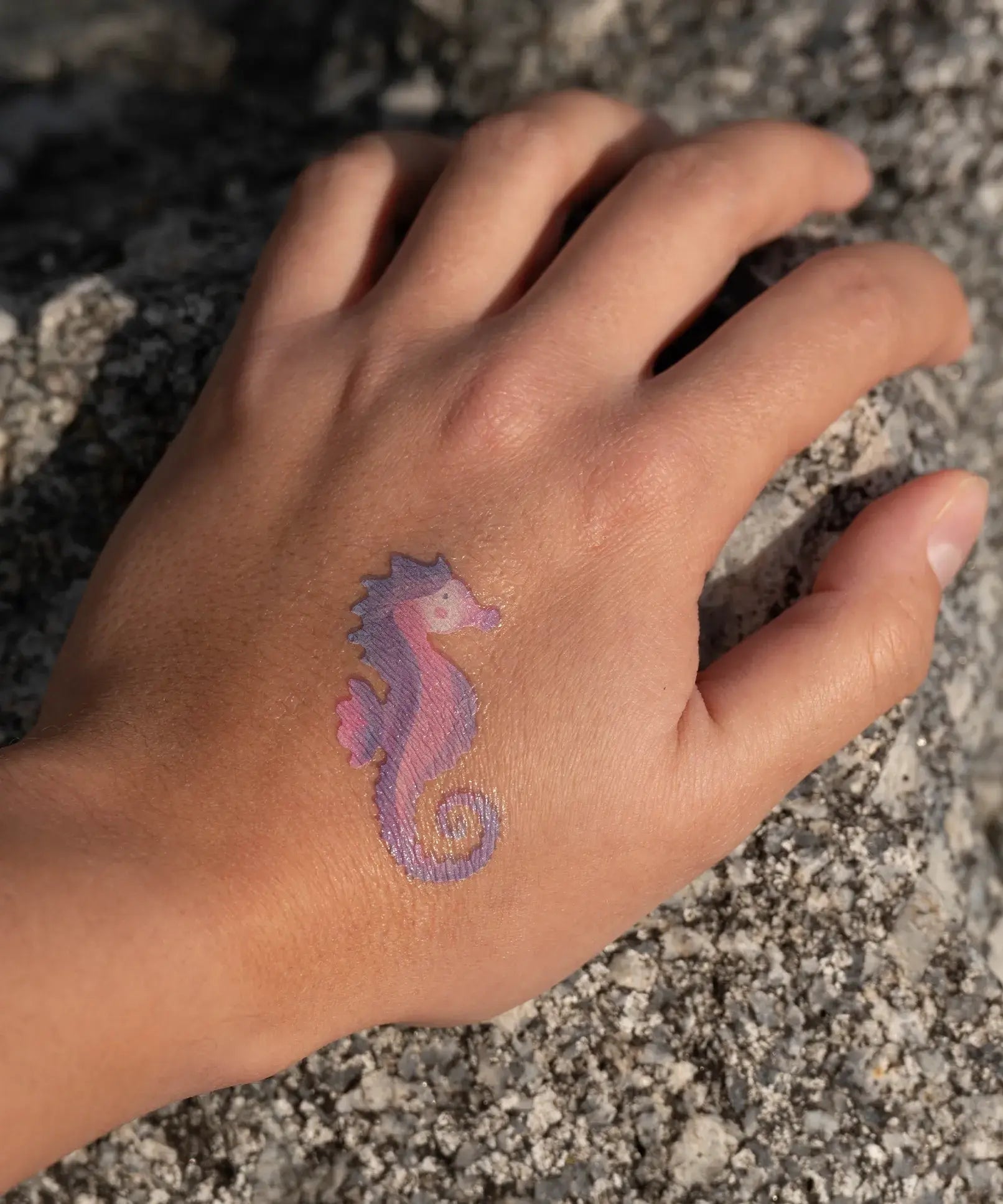 Seahorse tattoo from the Namaki mermaid face painting kit applied to a child's hand.