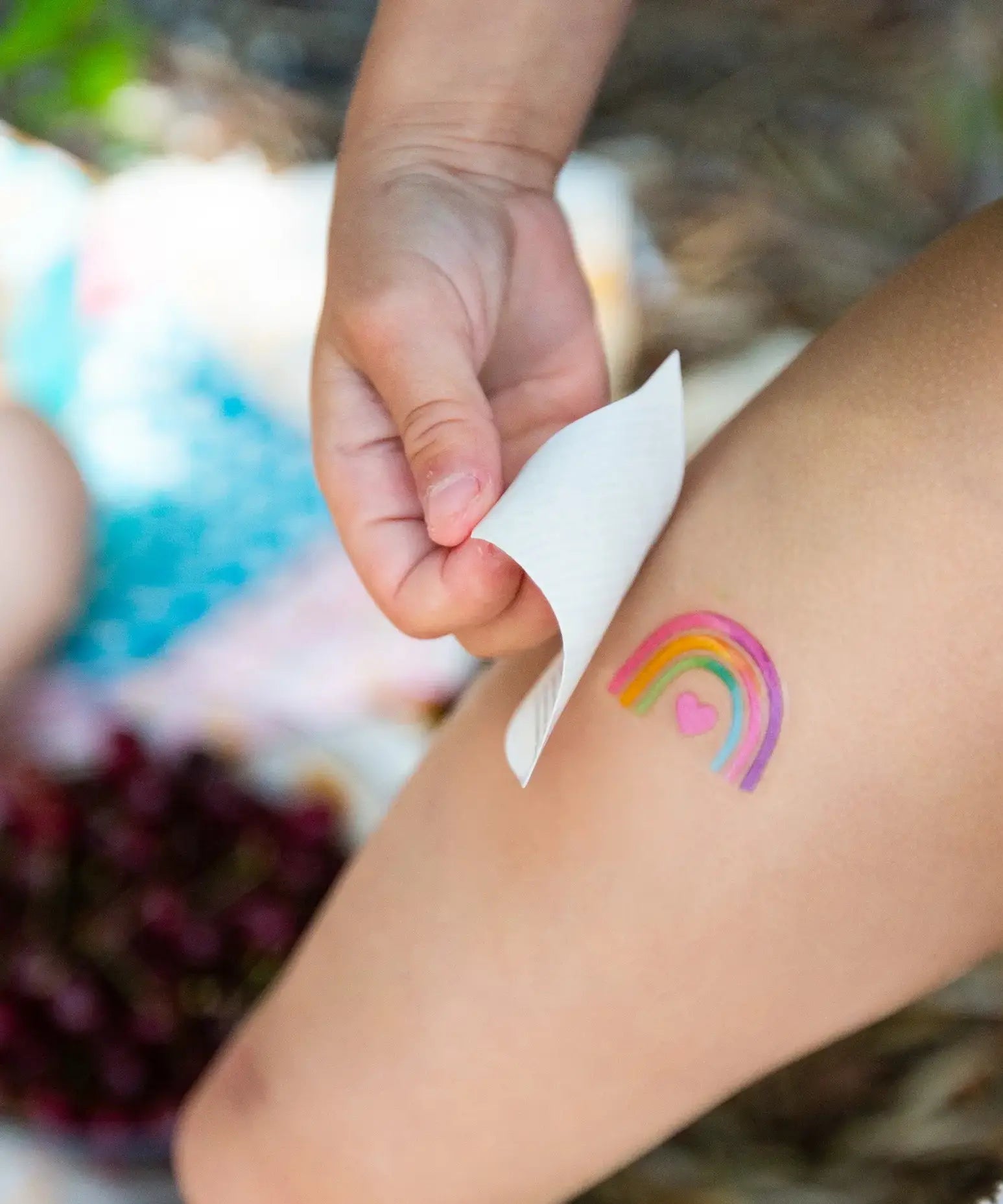 Rainbow tattoo from the Namaki unicorn face painting kit with four face paints, brush and a sheet of tattoos.