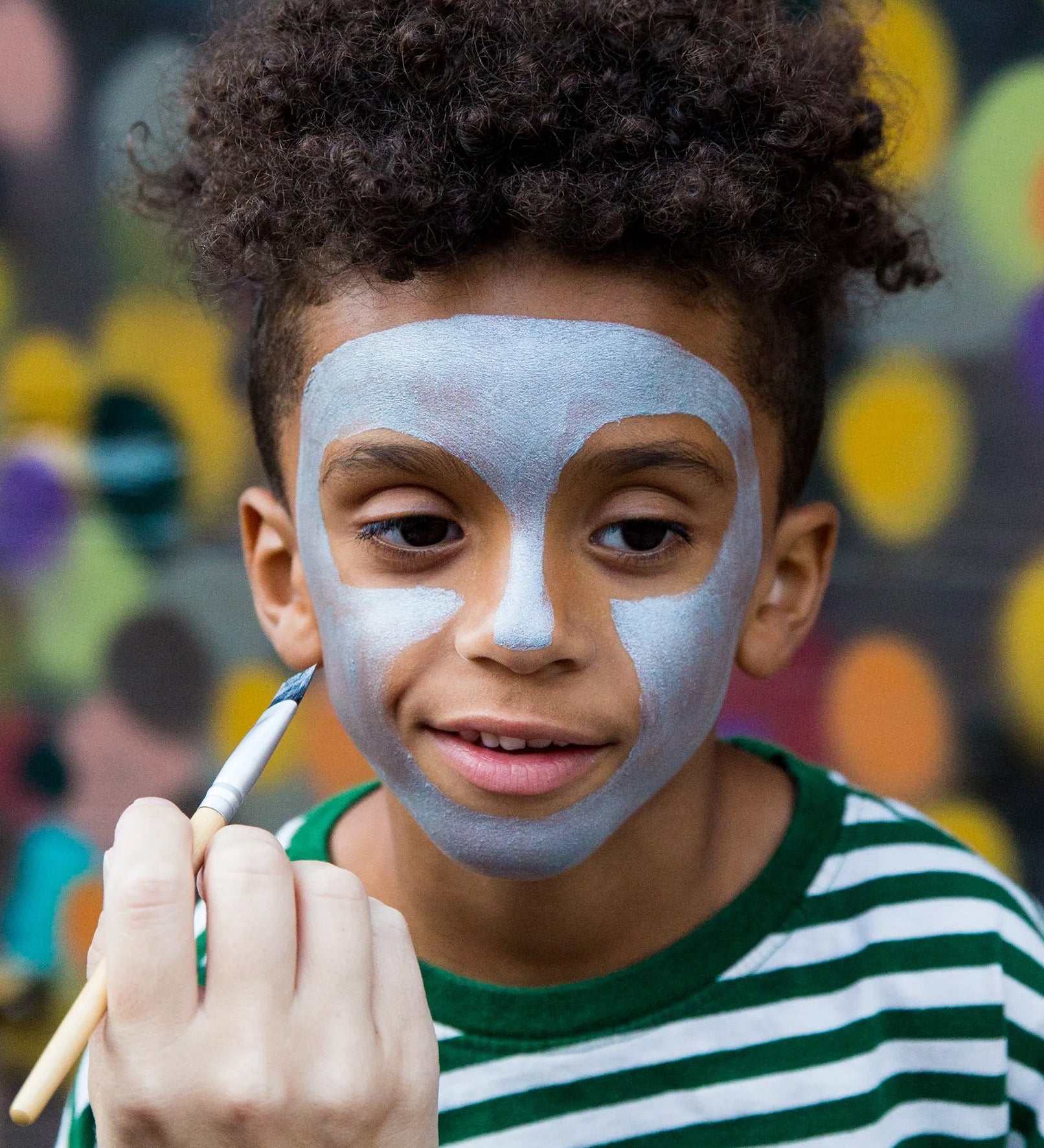 Child having face painted with Namaki natural water-based kids' blue face paint .