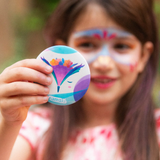 A girl looking at her face paint with the compact mirror from the Namaki non-toxic children's makeup Gift Set