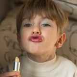 A little boy pouting, wearing the Namaki natural and organic certified child-friendly lip balm in vanilla flavour. 