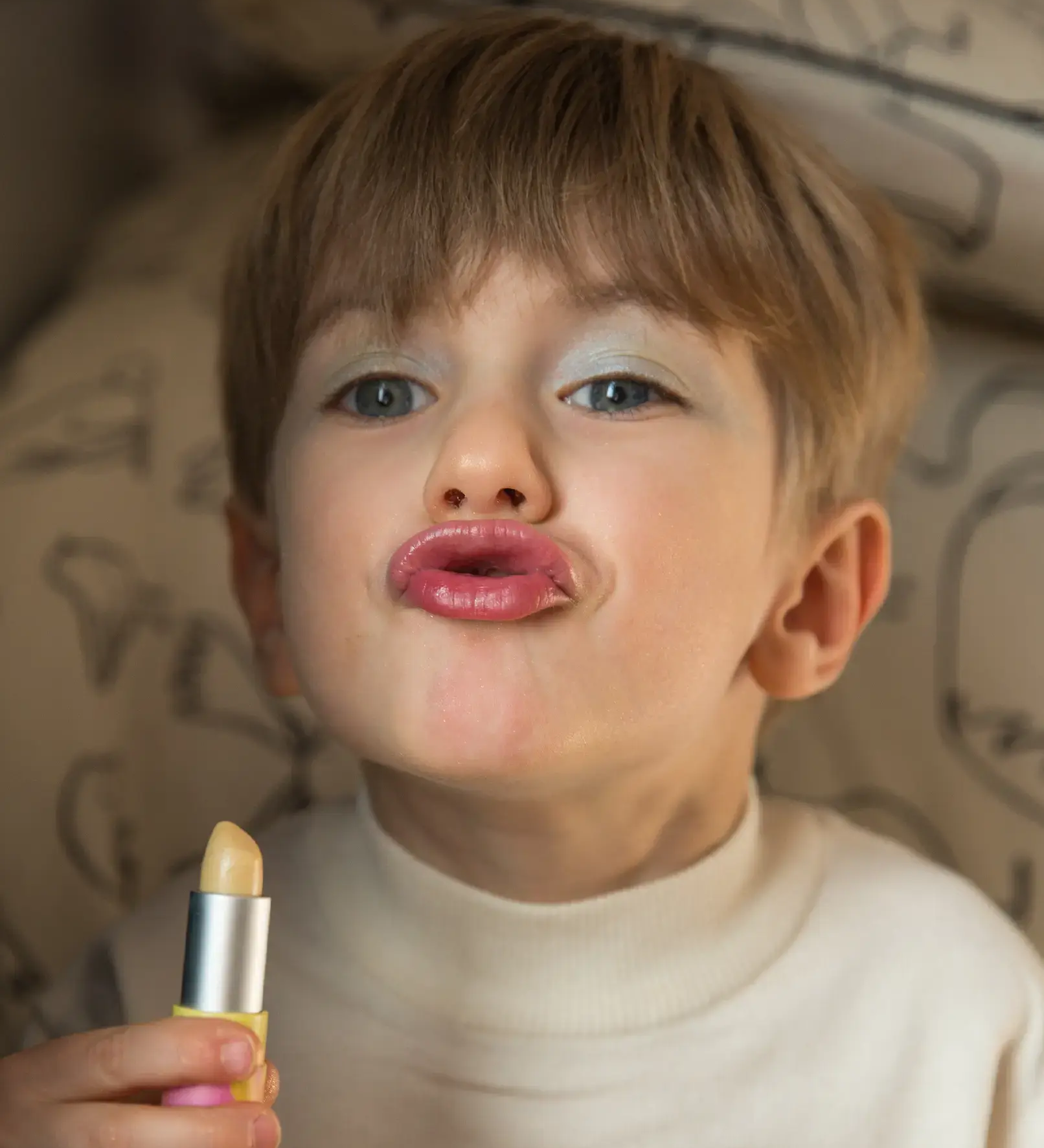 A little boy pouting, wearing the Namaki natural and organic certified child-friendly lip balm in vanilla flavour. 