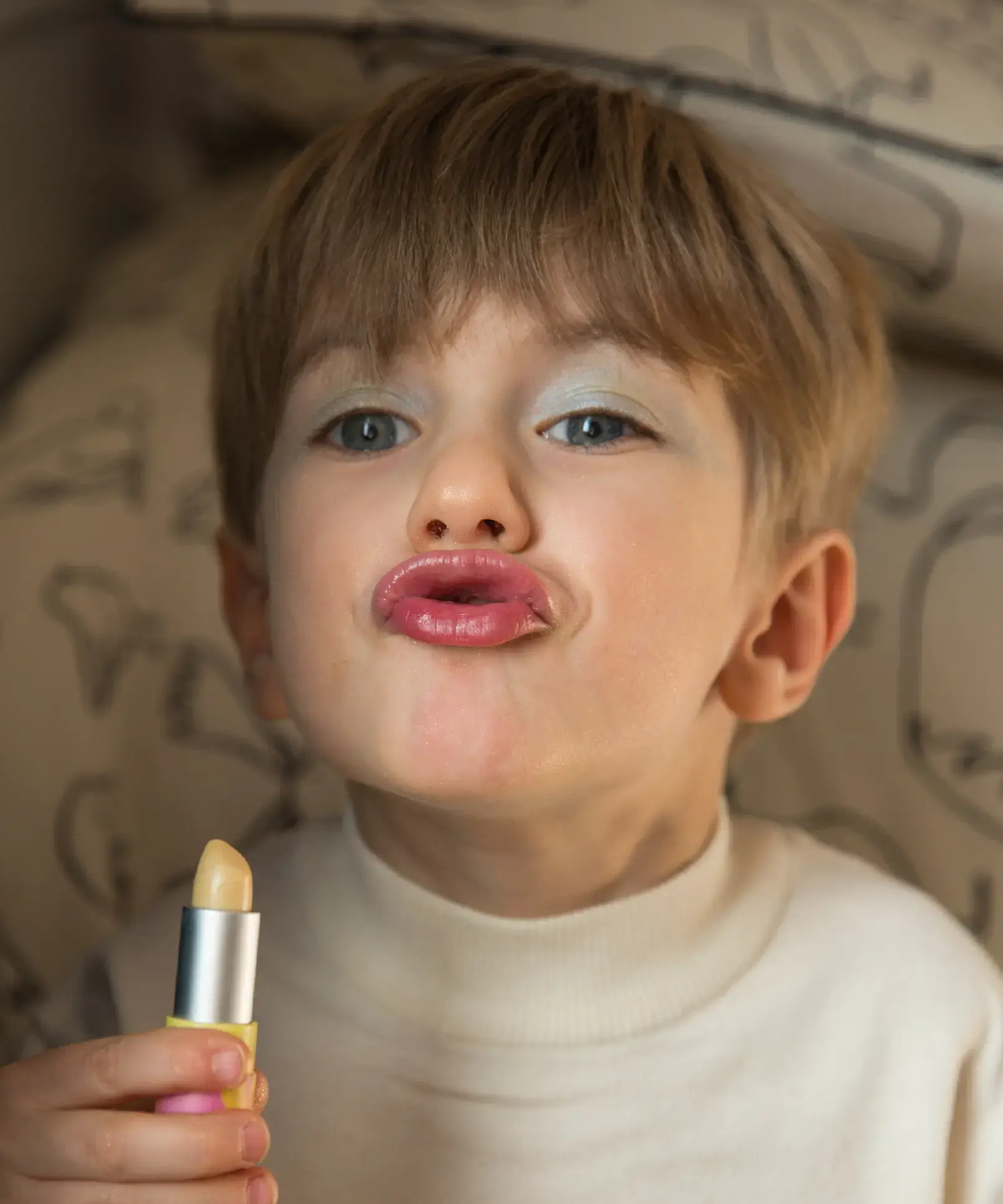 A little boy pouting, wearing the Namaki natural and organic certified child-friendly lip balm in vanilla flavour. 
