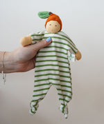A Nanchen Orange Baby Comforter Doll being held up in an adult's hand. 