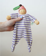A Nanchen peach Baby Comforter Doll being held up in an adult's hand. 