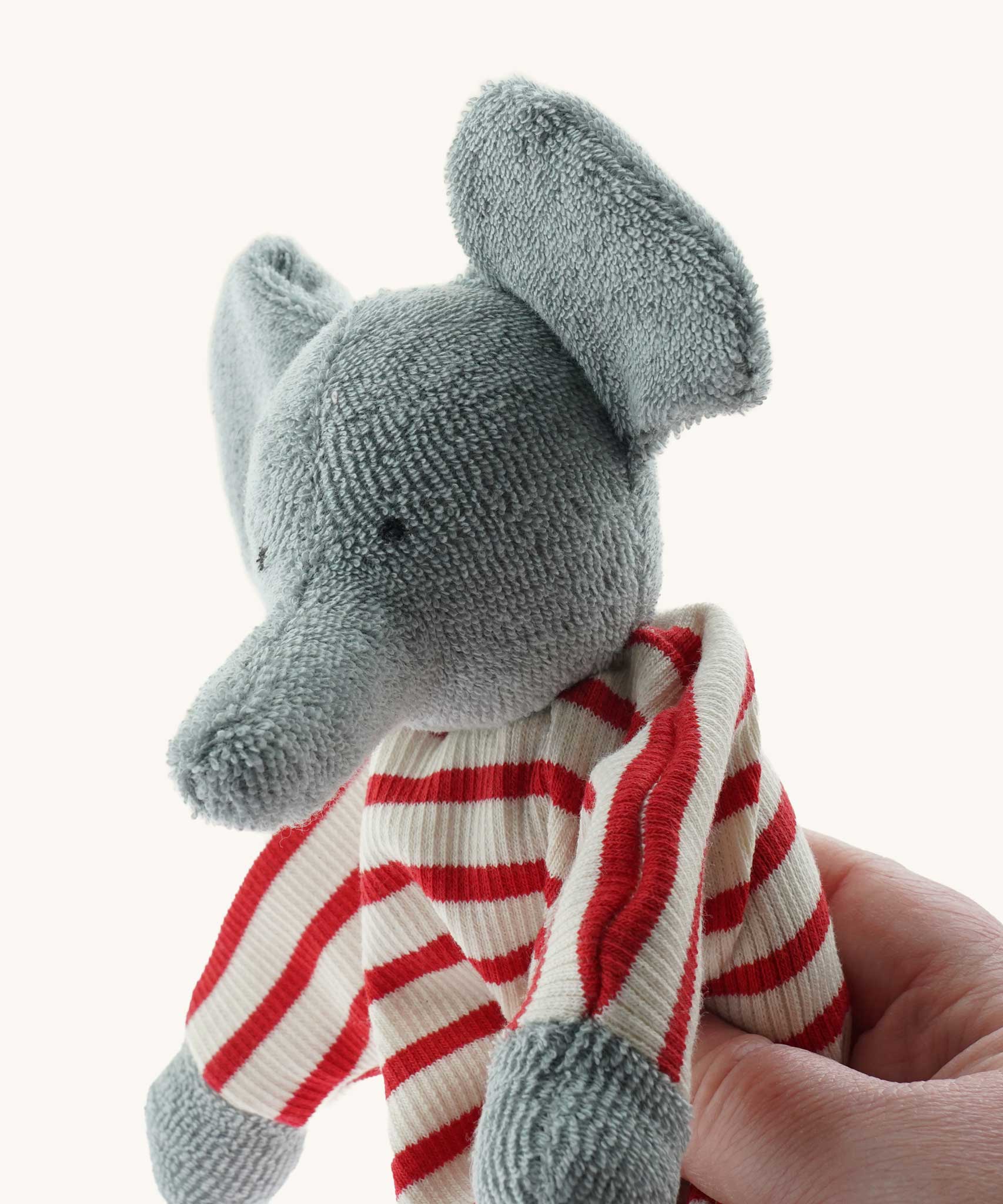 A close up of the Nanchen elephant baby comforter soft toy's trunk. The grey elephant has a red and white striped body.