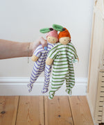 Nanchen peach and orange Baby Comforter Dolls being held up in an adult's hand.