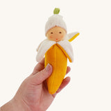 A Nanchen banana Baby Rattle Doll in an adult's hand. 
