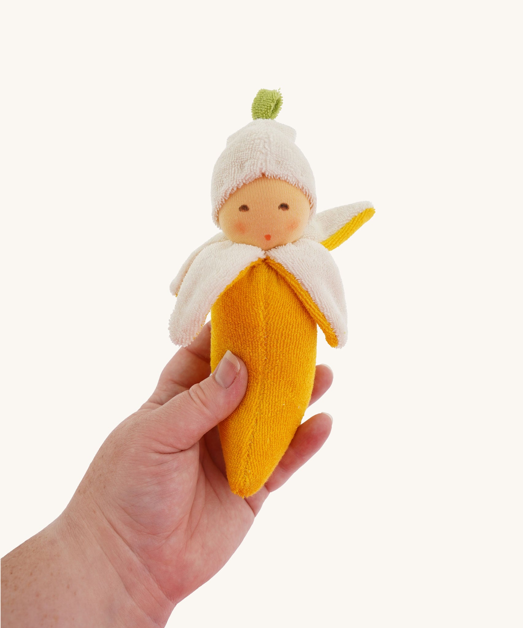 A Nanchen banana Baby Rattle Doll in an adult's hand. 