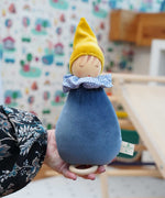 A close up of a Nanchen Dream King Frog Lullaby Music Doll in a child's hand. A musical Waldorf doll, made from organic cotton and sheep's wool. 