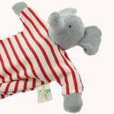 A close up of the Nanchen elephant baby comforter soft toy. The grey elephant has a red and white striped body.
