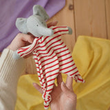 Nanchen elephant striped baby comforter doll in an adult's hand in the Babipur playroom.