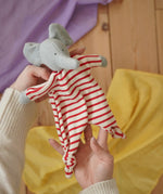 Nanchen elephant striped baby comforter doll in an adult's hand in the Babipur playroom.