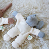 A Nanchen Elephant Teddy Rattle placed on a sheepskin rug.