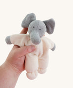 A Nanchen Elephant Teddy Rattle being held in an adult's hand.