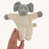 A Nanchen Elephant Teddy Rattle shown with an adult's hand reaching for it.