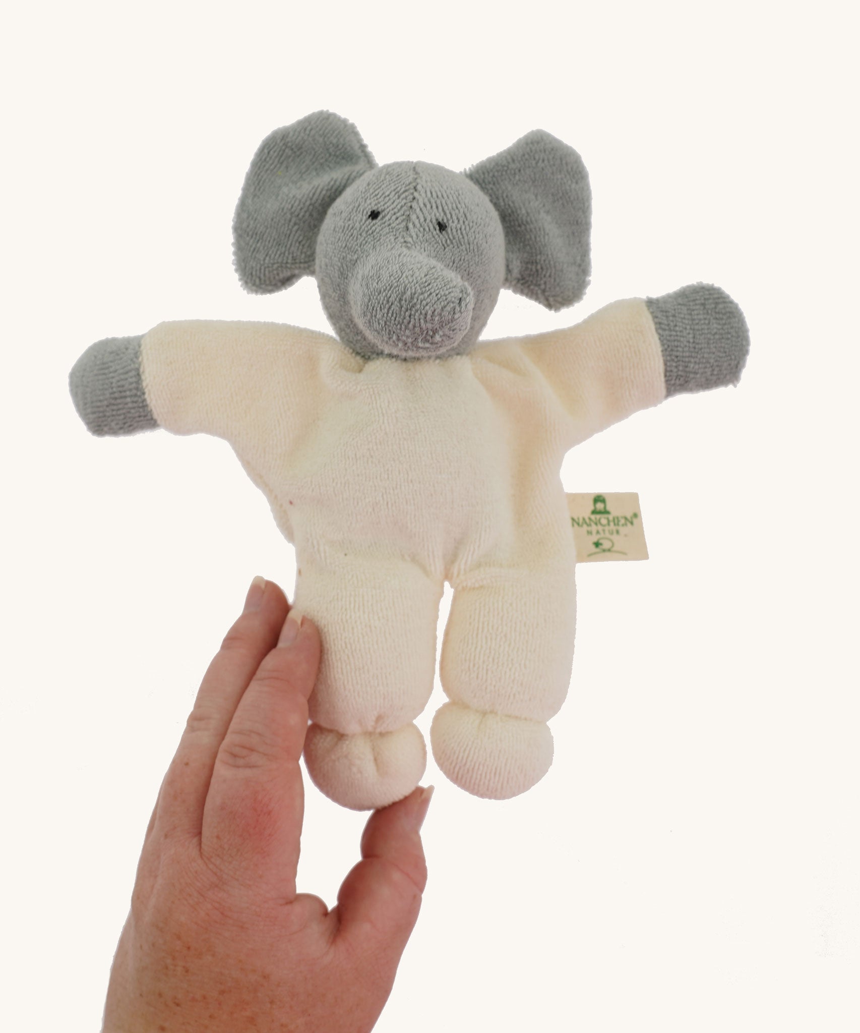 A Nanchen Elephant Teddy Rattle shown with an adult's hand reaching for it.