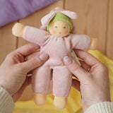 Nanchen flower fairy Waldorf rattle doll in an adult's hands in the Babipur playroom.