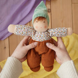 Nanchen Forest Child Waldorf doll in brown in an adult's hand in the Babipur playroom.