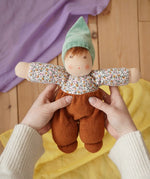 Nanchen Forest Child Waldorf doll in brown in an adult's hand in the Babipur playroom.