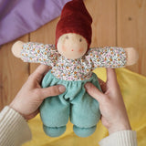 Nanchen mint forest child Waldorf doll in an adult's hands in the Babipur playroom.