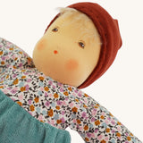 A close up of the face of the sage coloured Nanchen Forest Child Waldorf organic, handcrafted Doll.