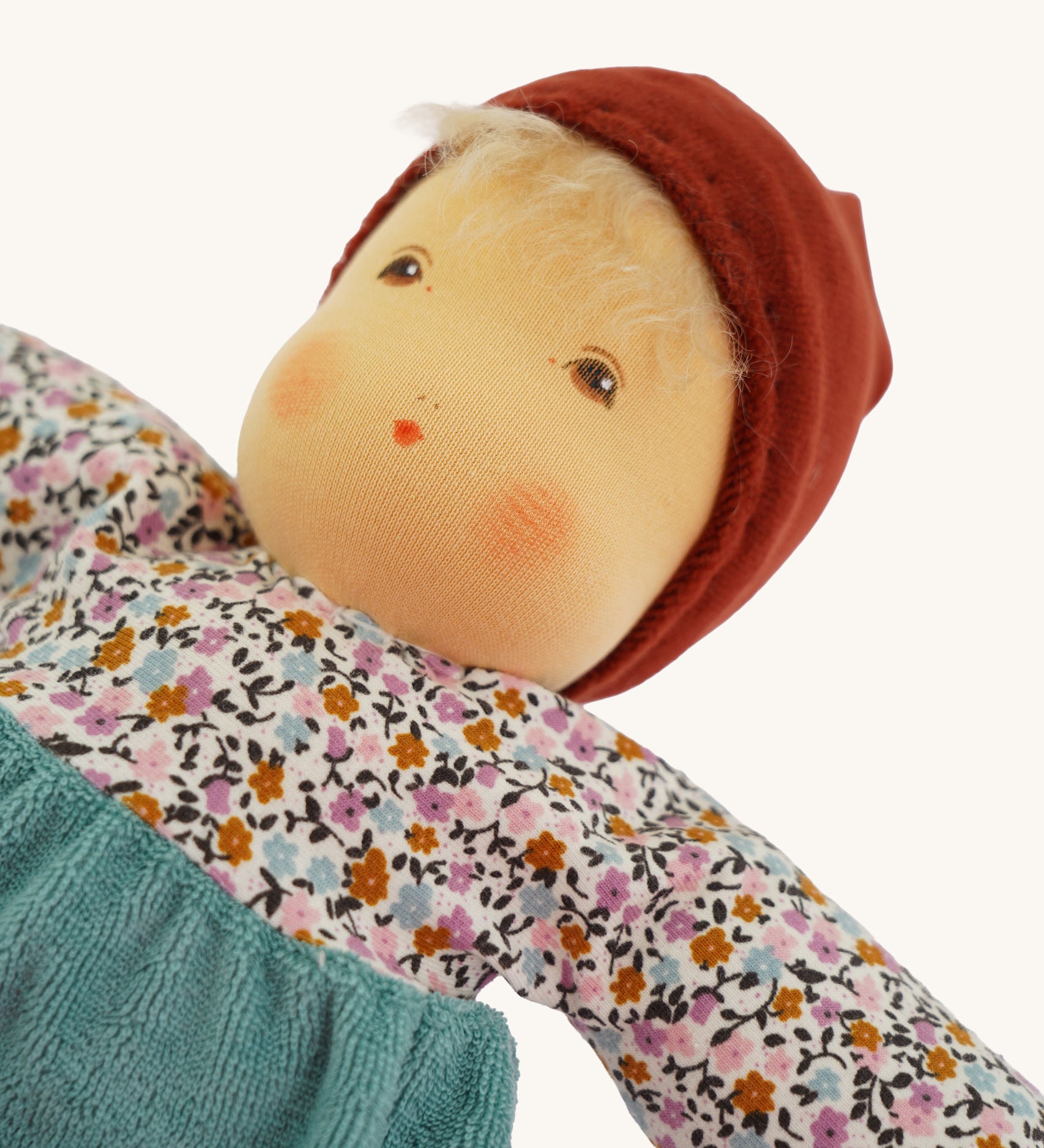 A close up of the face of the sage coloured Nanchen Forest Child Waldorf organic, handcrafted Doll.