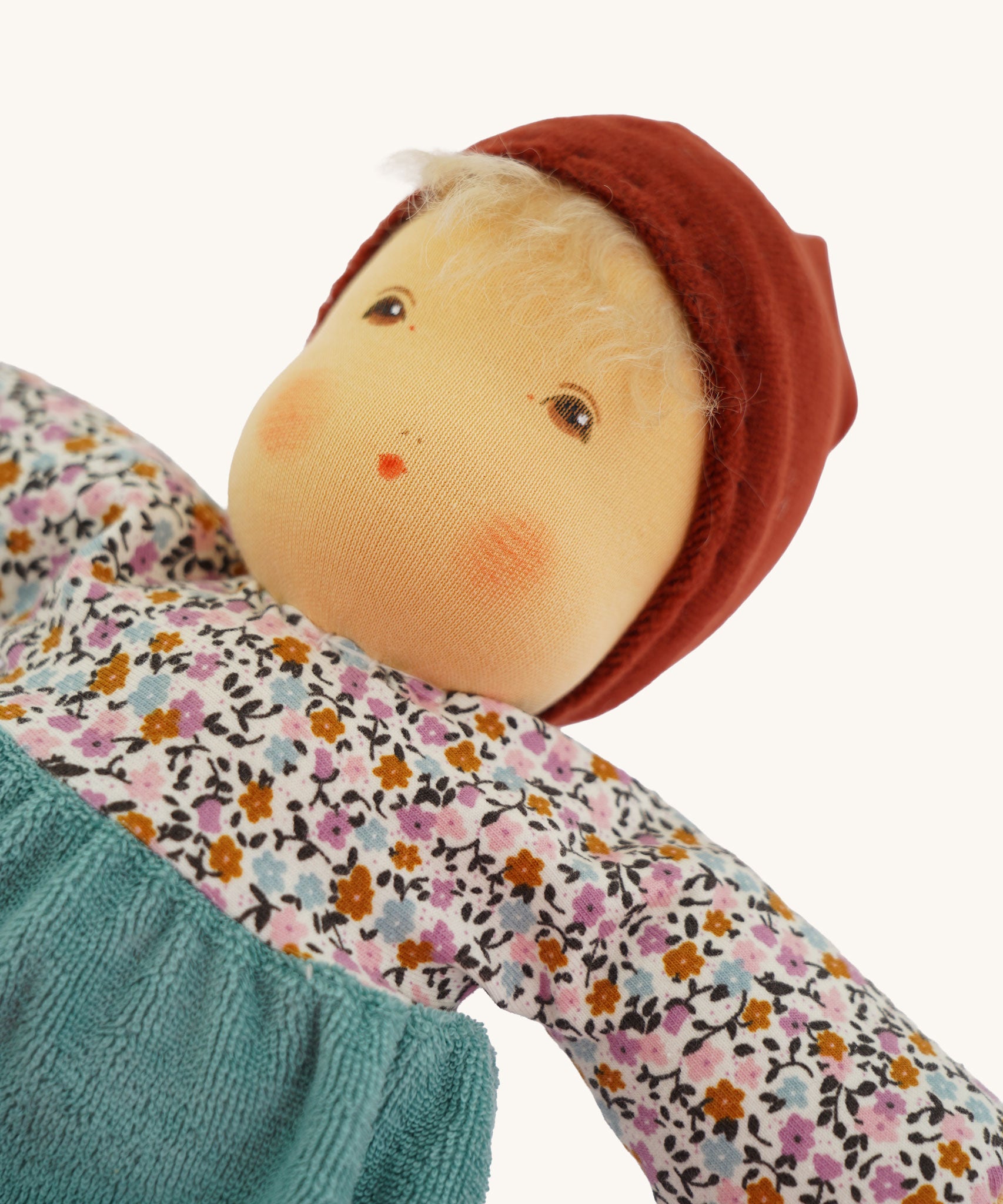 A close up of the face of the sage coloured Nanchen Forest Child Waldorf organic, handcrafted Doll.