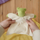 Nanchen Natur frog toweling baby comforter in an adult's hands in the Babipur playroom. 