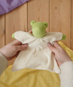 Nanchen Natur frog toweling baby comforter in an adult's hands in the Babipur playroom. 