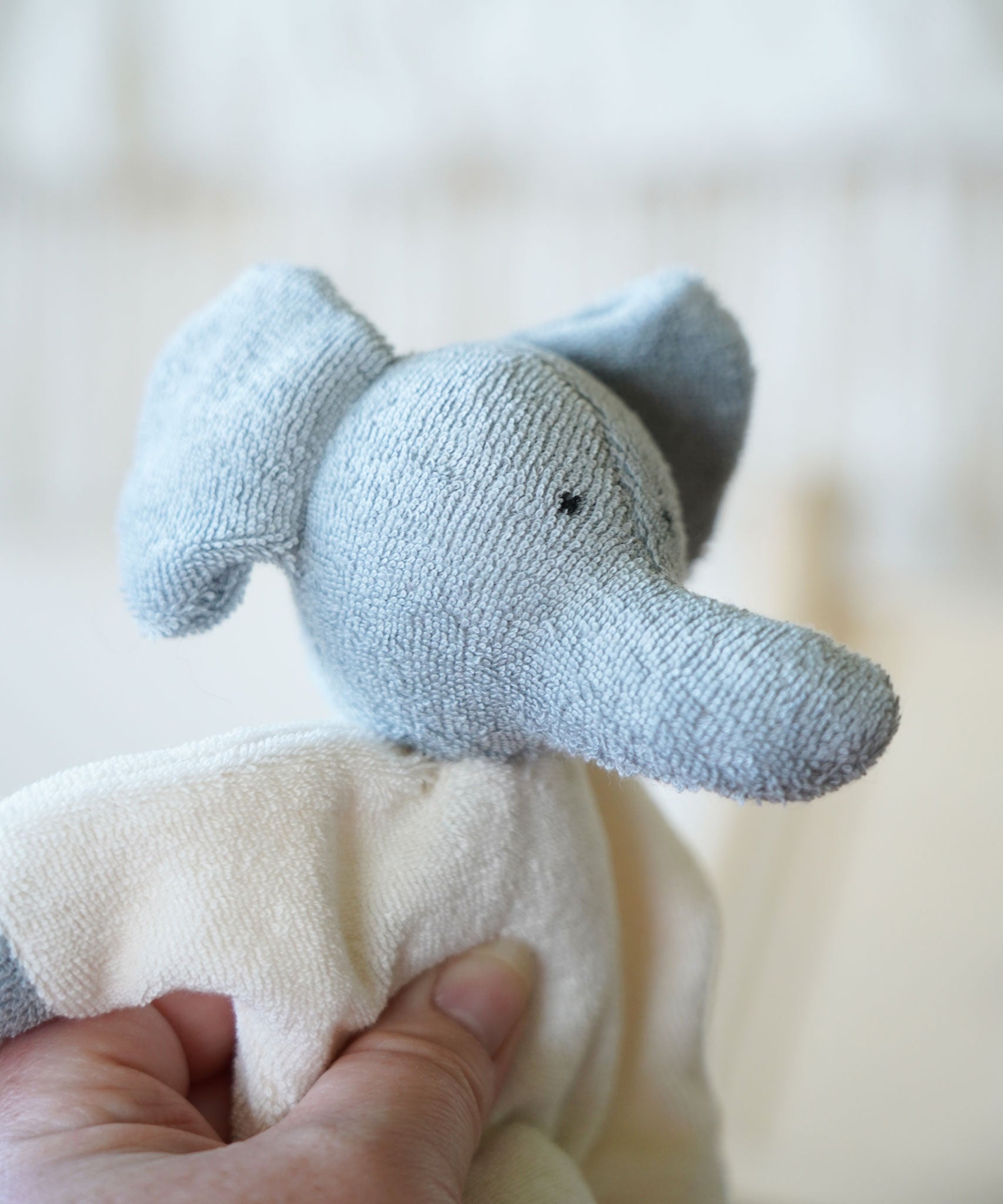 A close up of the Nanchen Elephant Teddy Rattle face, showing the texture of the material.