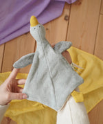 Nanchen grey goose baby comforter shown on an adult's hand in the Babipur playroom. 