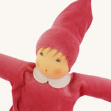 A close up of the face of the Nanchen Nani Waldorf Doll with pink outfit and hat.
