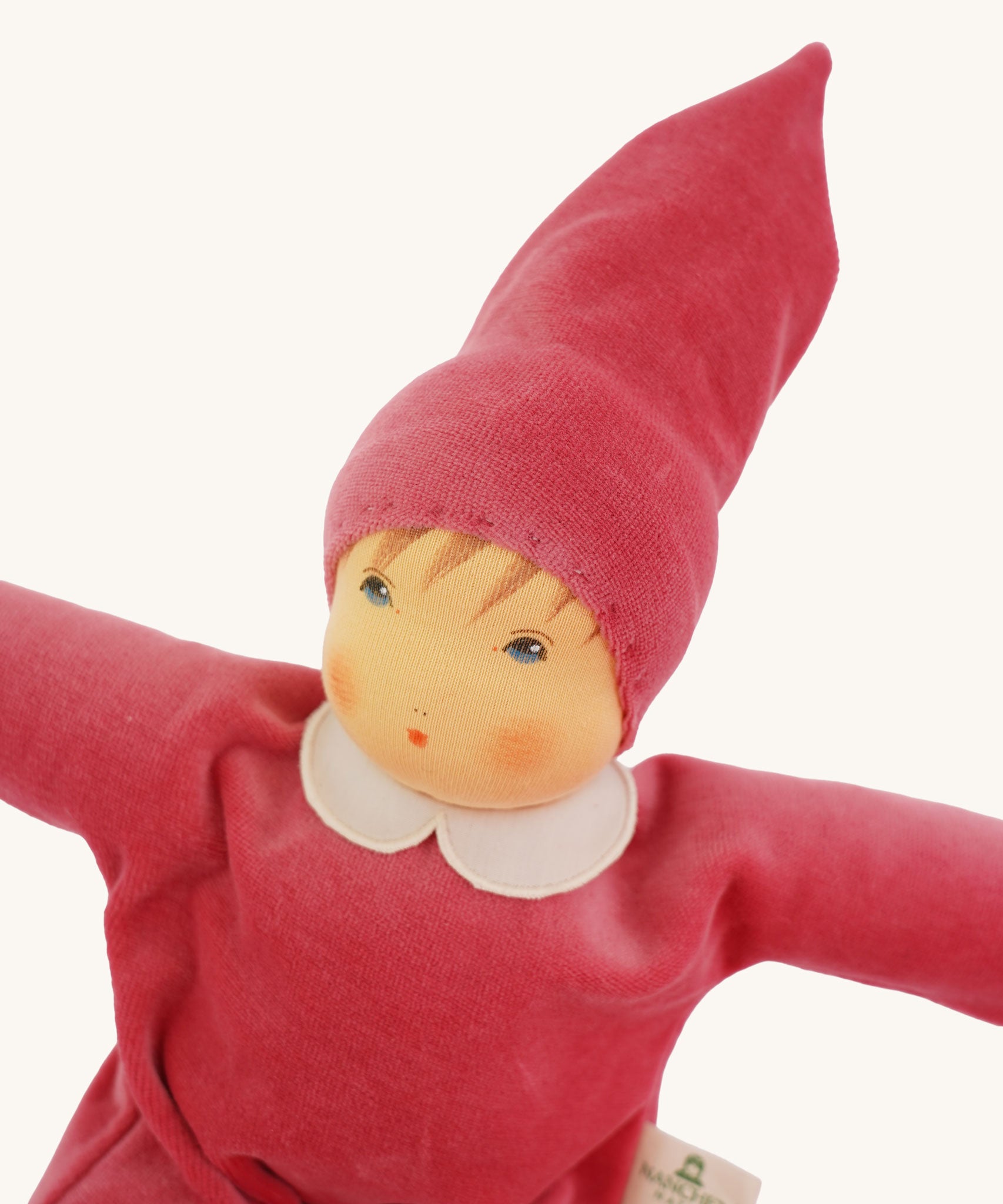 A close up of the face of the Nanchen Nani Waldorf Doll with pink outfit and hat.
