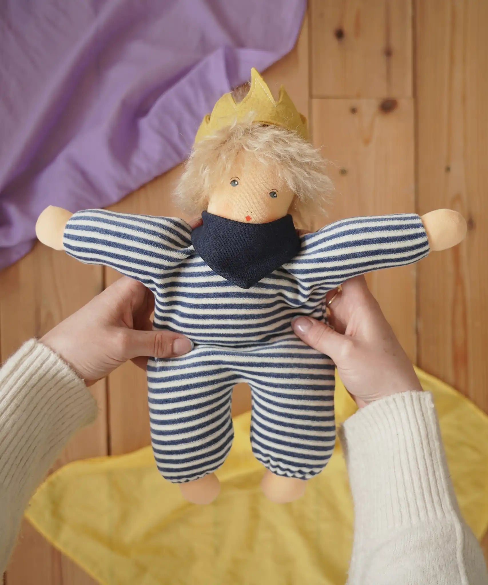 Nanchen King Karl Waldorf doll in an adult's hands in the Babipur playroom. 