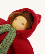 A close up of the  Nanchen handcrafted Little Red Riding Hood Waldorf doll#f face with the clothing on and the hood of the coat up.
