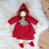 The  Nanchen handcrafted Little Red Riding Hood Waldorf doll shown placed on a sheepskin rug. 