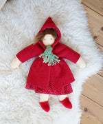 The  Nanchen handcrafted Little Red Riding Hood Waldorf doll shown placed on a sheepskin rug. 