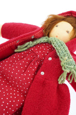 A close up of the popper closure on the  Nanchen handcrafted Little Red Riding Hood Waldorf doll's red coloured coat.