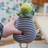 The Nanchen Brave Little Frog Lullaby Music Doll shown in an adult's hand. A musical Waldorf doll, made from organic cotton and sheep's wool. 