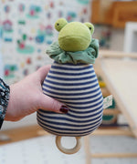The Nanchen Brave Little Frog Lullaby Music Doll shown in an adult's hand. A musical Waldorf doll, made from organic cotton and sheep's wool. 